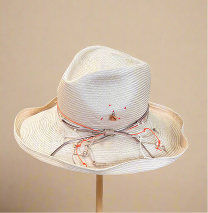 Light straw hat with white and orange decorative ribbon on a beige background